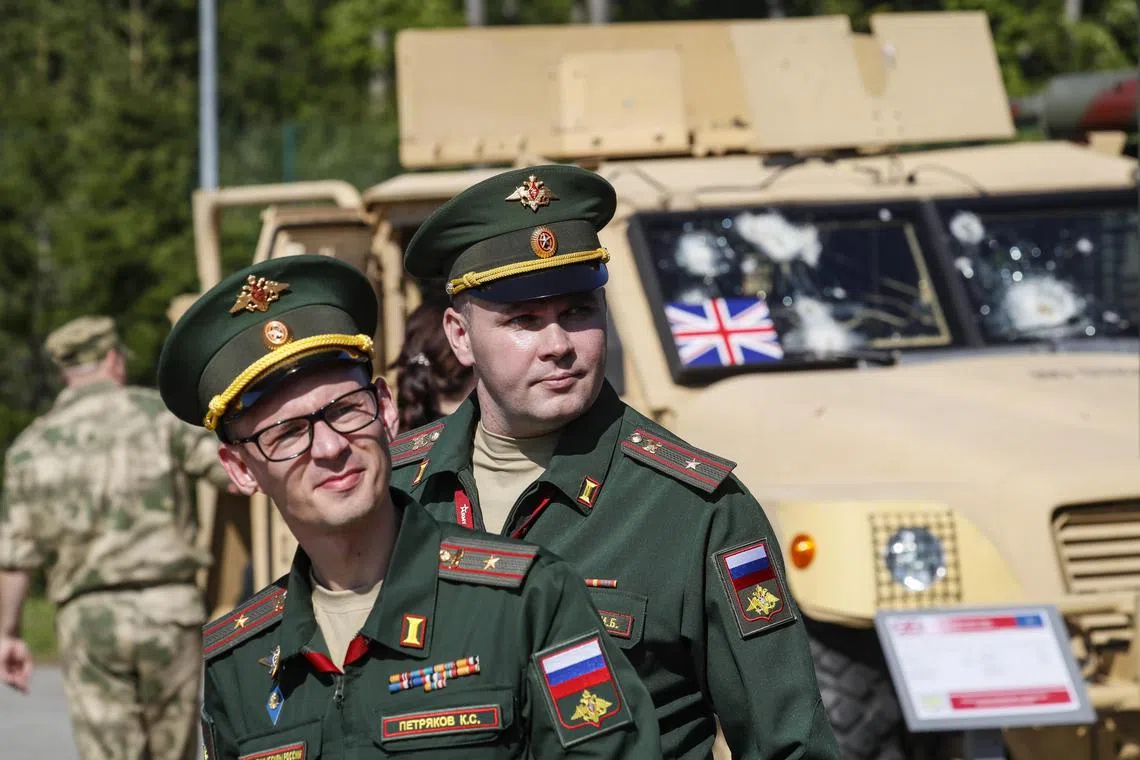 Russian servicemen are seen in front of a British Husky vehicle during the exhibition of captured equipment at the Patriot Park in Kubinka, outside Moscow, on Aug 15.