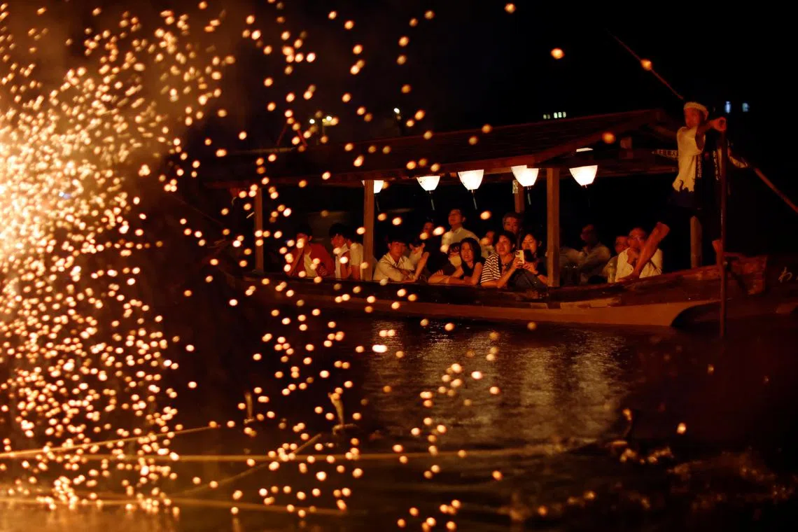 Spectators watching cormorant fishing master, known as usho, Youichiro Adachi (not pictured), 48, from a viewing boat on the Nagara River in Oze, Seki, Japan, Sept 8, 2023. 
