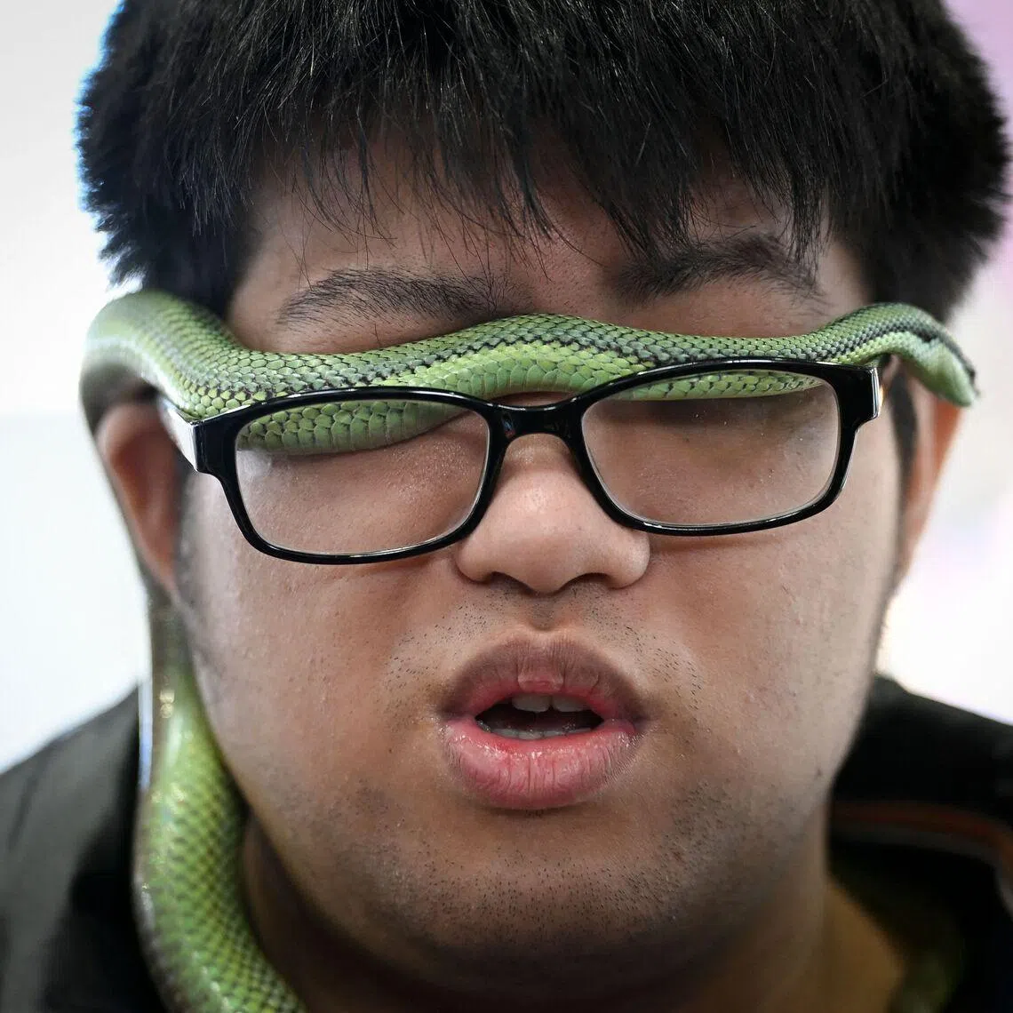A visitor with his pet snake at a pet fair in Beijing, on March 19, 2026. 