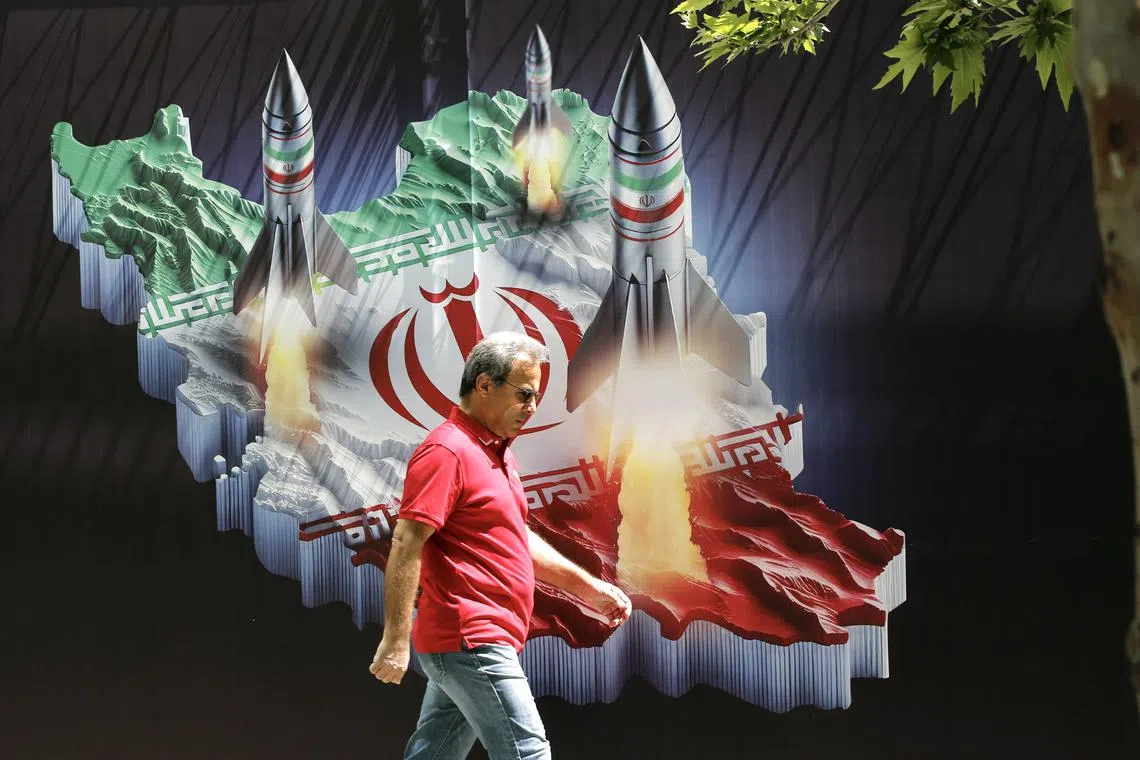 An Iranian man walks past a huge anti-Israeli banner carrying pictures of missiles on Iran's map, in Tehran, Iran, 19 April 2024.