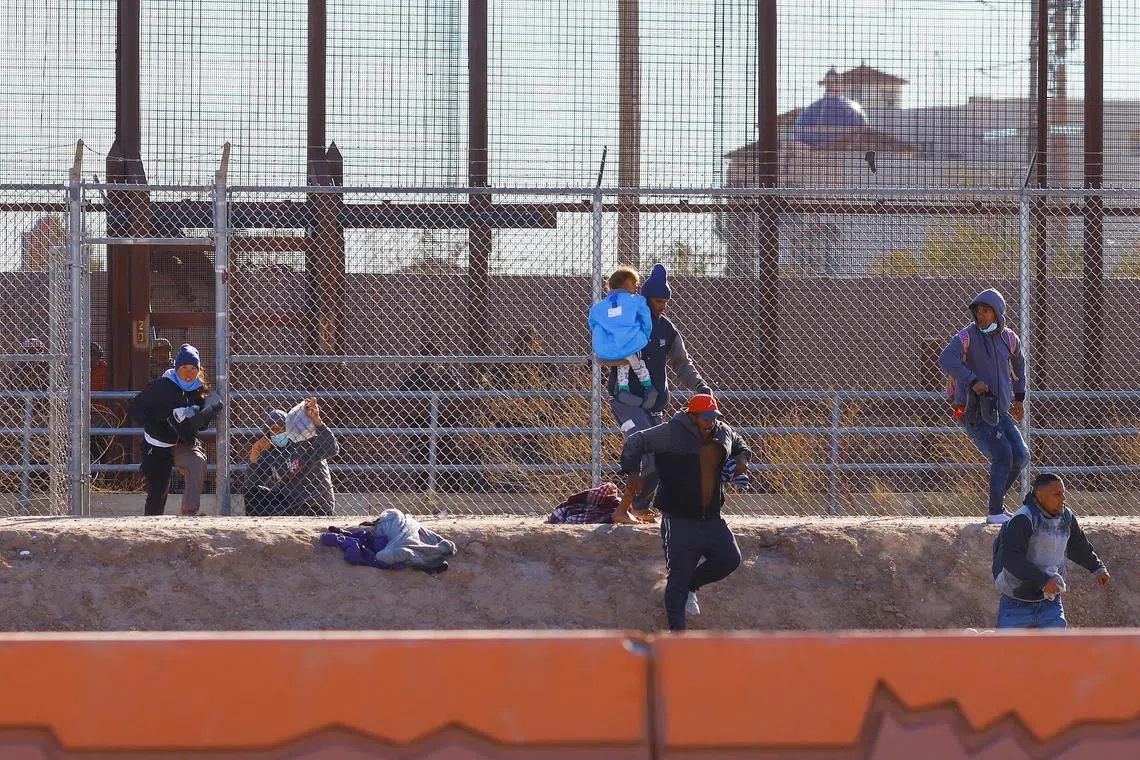Migrants run to hide from the US Border Patrol and Texas State Troopers after crossing into the United States from Mexico, in El Paso., Dec 23, 2022. 