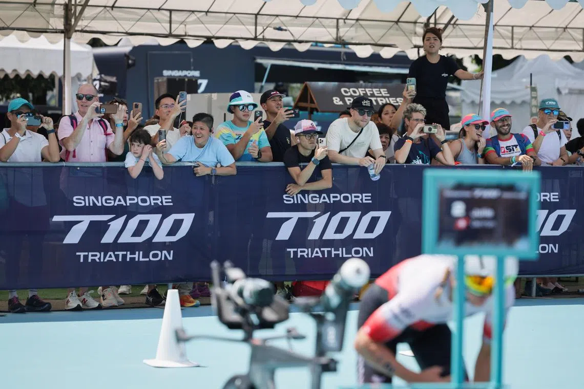 Spectators photographing the participants during the women's T100 Triathlon, held at Singapore's Marina Bay District on April 5, 2025.