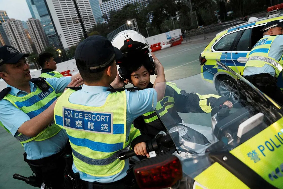 A student wearing a police uniform riding a police motorcycle at a carnival to mark the National Security Education Day in Hong Kong, China, April 15, 2024. 