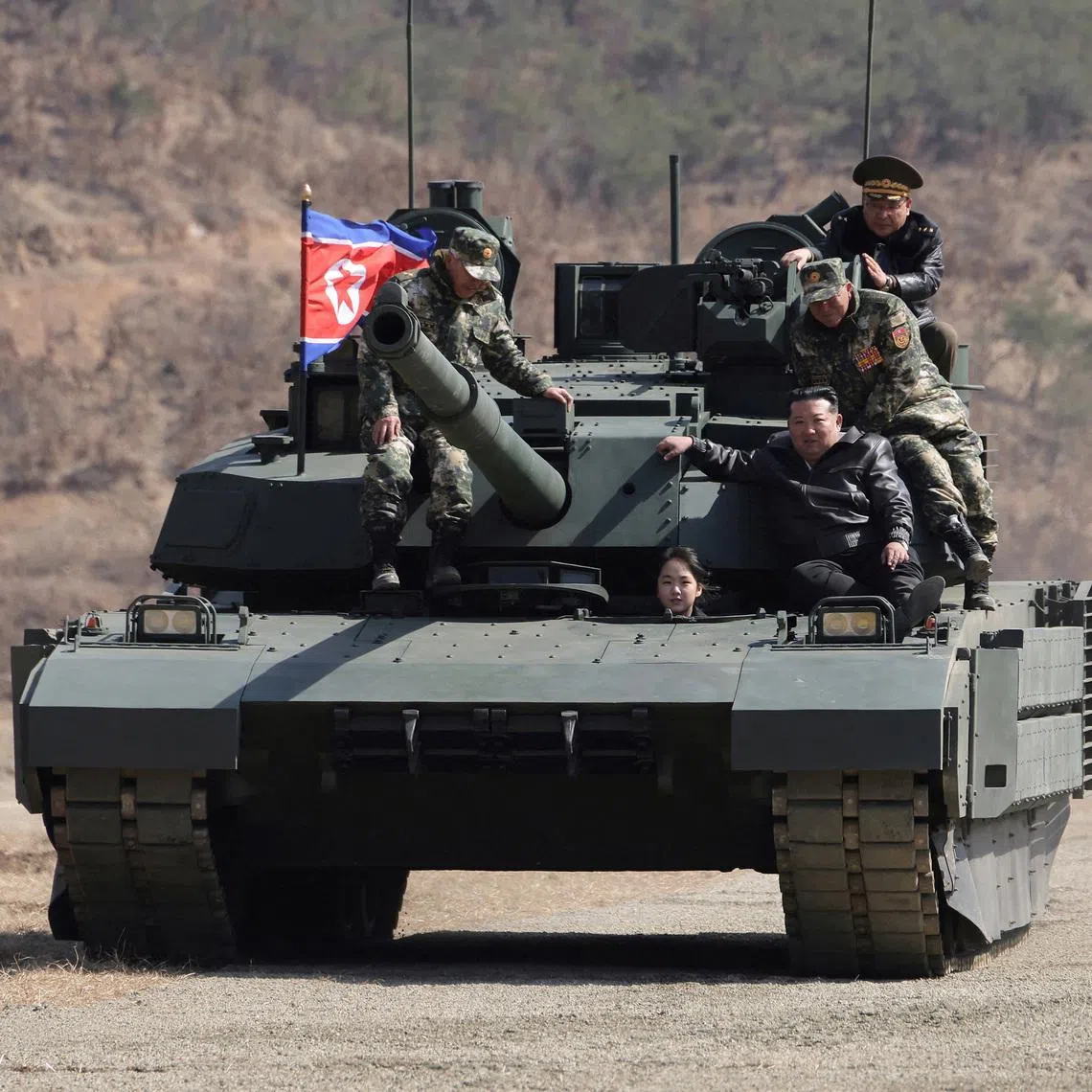 North Korean leader Kim Jong Un and his daughter Kim Ju Ae ride a tank during what North Korean state news agency KCNA reports is an offensive tactical drill involving a new type of tank, at a training base in Pyongyang, North Korea, March 19, 2026, in this picture released by North Korea's official Korean Central News Agency. KCNA via REUTERS