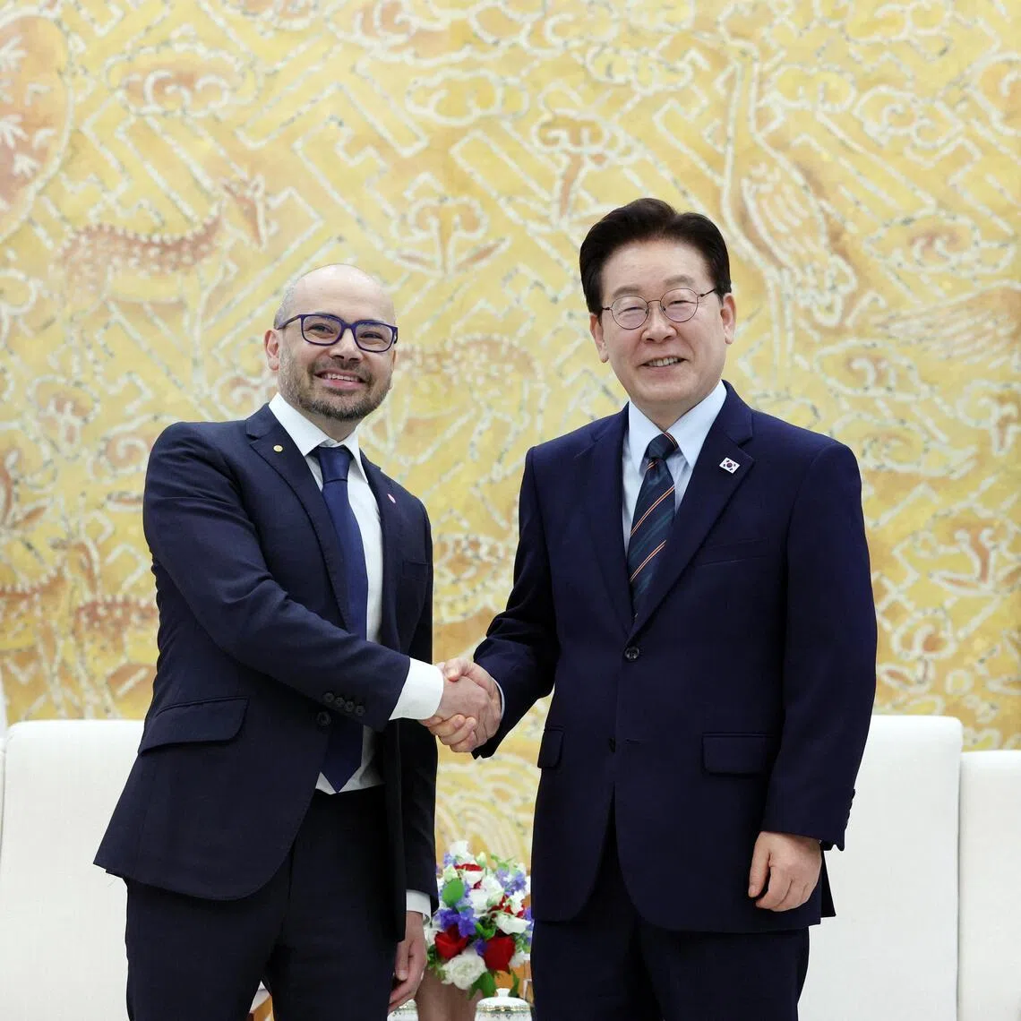 South Korean President Lee Jae Myung (R) shakes hands with Demis Hassabis (L), co-founder and CEO of Google DeepMind, during their meeting in Seoul, South Korea.