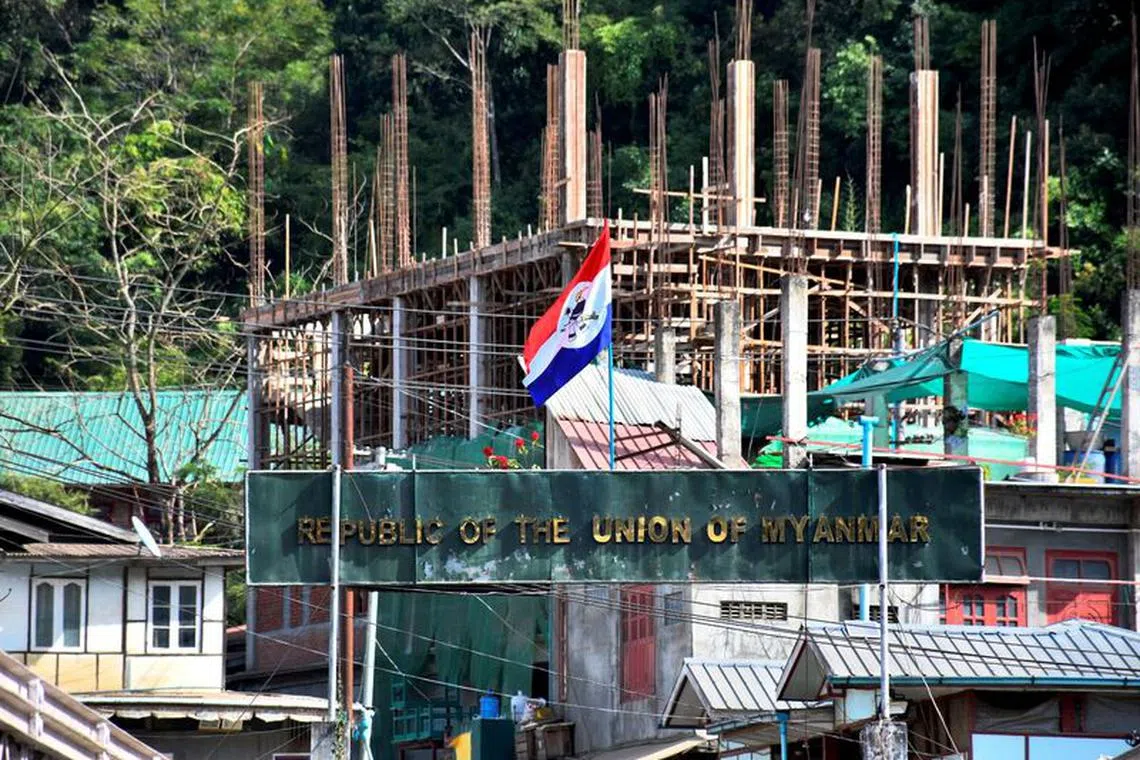 A flag of one of the Myanmar rebel forces is installed next to an under-construction structure in Myanmar's Khawmawi village on the India-Myanmar border as seen from Zokhawthar village in Champhai district of India's northeastern state of Mizoram, India, November 14, 2023. REUTERS/Chanchinmawia