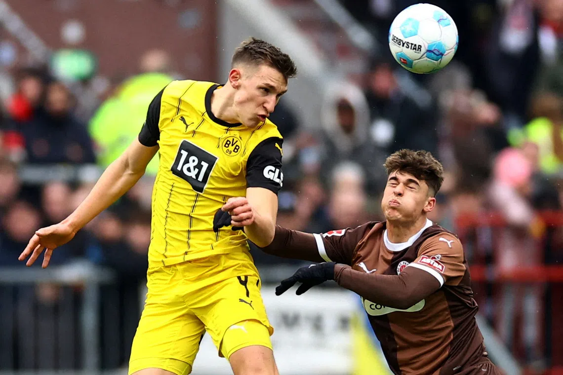 FILE PHOTO: Soccer Football - Bundesliga - FC St. Pauli v Borussia Dortmund - Millerntor-Stadion, Hamburg, Germany - March 1, 2025 Borussia Dortmund's Nico Schlotterbeck in action with FC St. Pauli's Noah Weisshaupt REUTERS/Lisi Niesner/File Photo