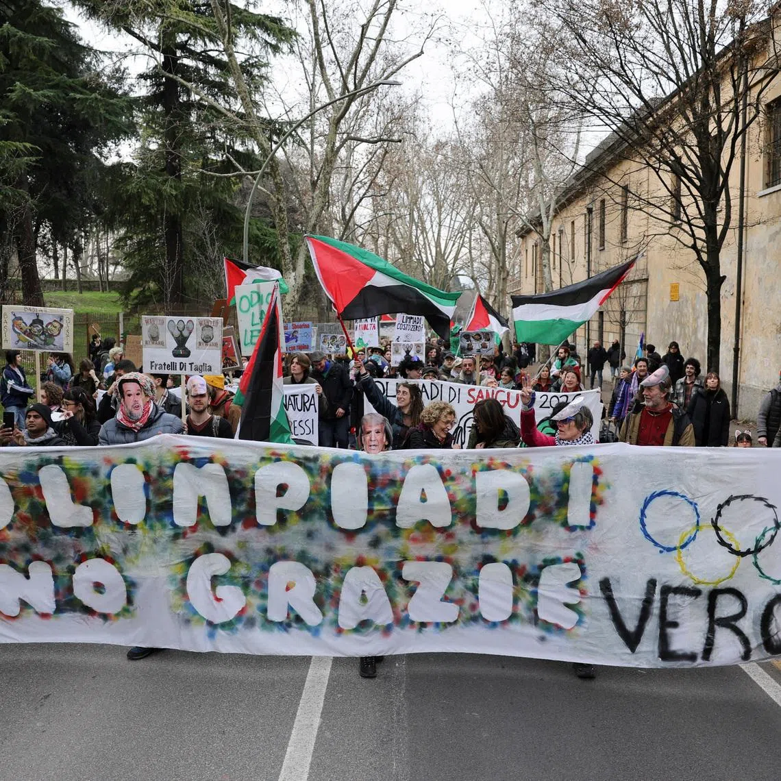 Protesters hold a banner reading "Olympics - No Thanks" on the day of the Winter Olympics closing ceremony.
