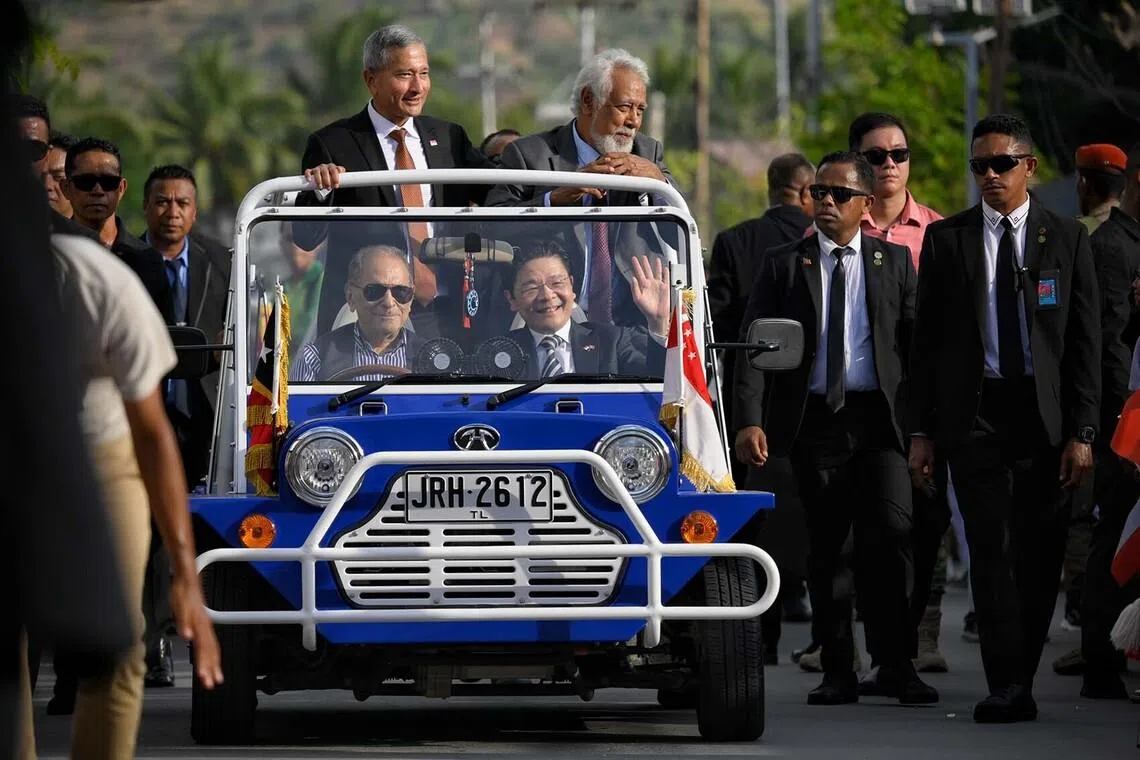 Timor Leste school children line the streets leading to the delegation hotel as Singapore Prime Minister Lawrence Wong (centre) rides on a mini moke driven by Timor Leste president Jos Ramos-Horta from the airport, with Singapore Foreign Minister Vivian Balakrishnan and Timor Leste Prime Minister Xanana Gusmao, on July 2, 2026.