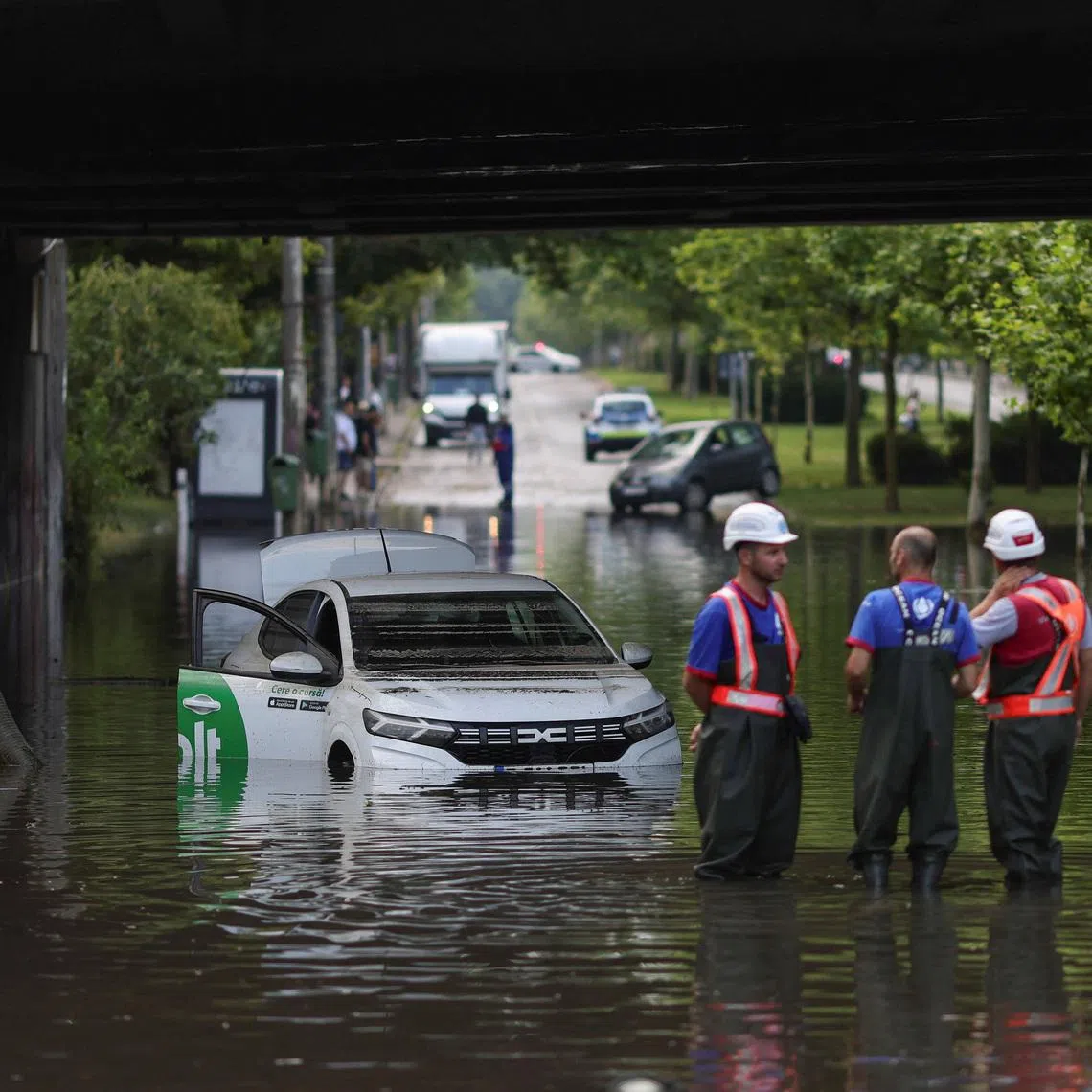 Workers watch as rainwater is pumped out of a flooded railway underpass in northern Bucharest, Romania, July 1, 2026. Inquam Photos/Octav Ganea via REUTERS