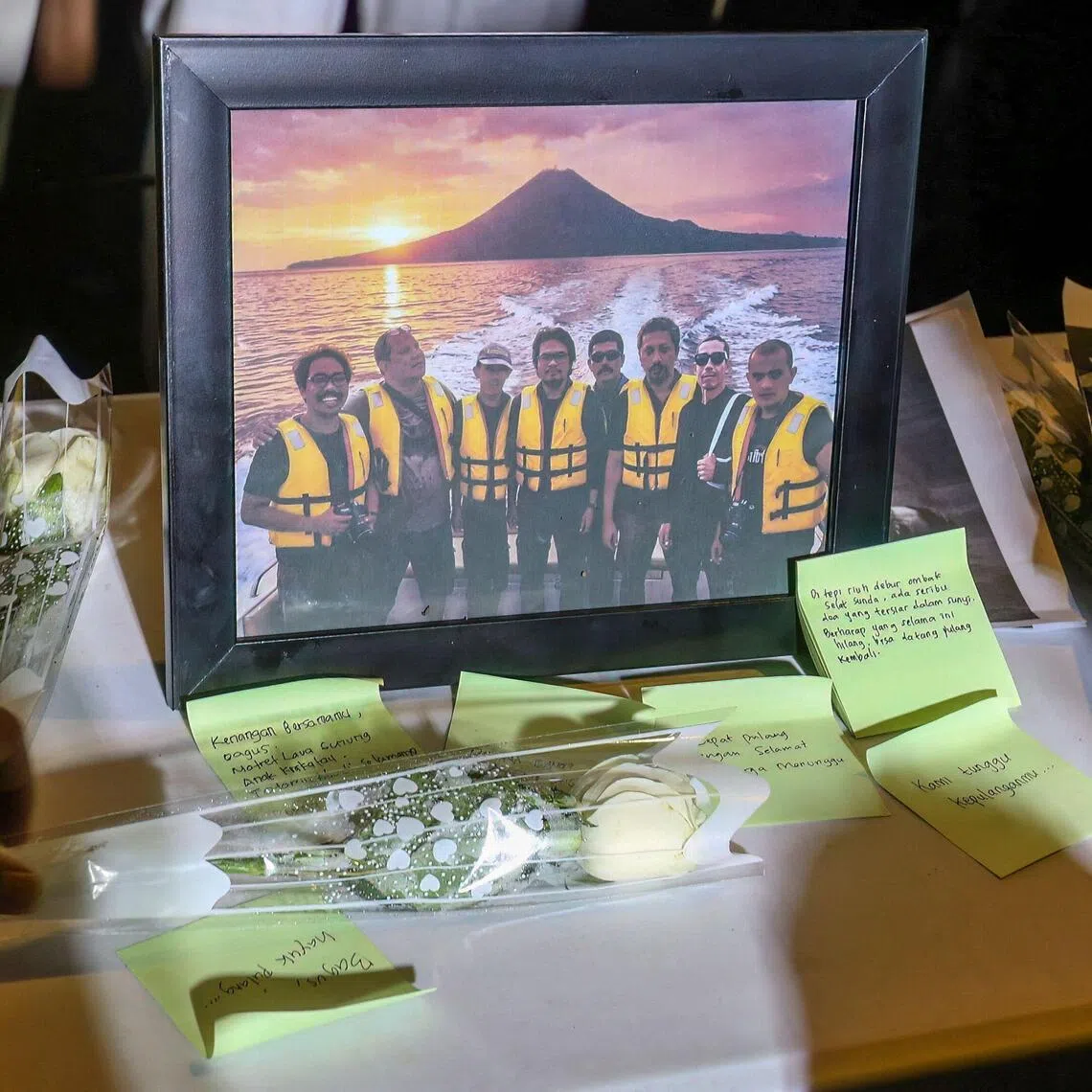 Flowers adorn a photo of the journalists and speedboat crew missing while covering the eruption of Mount Anak Krakatau.