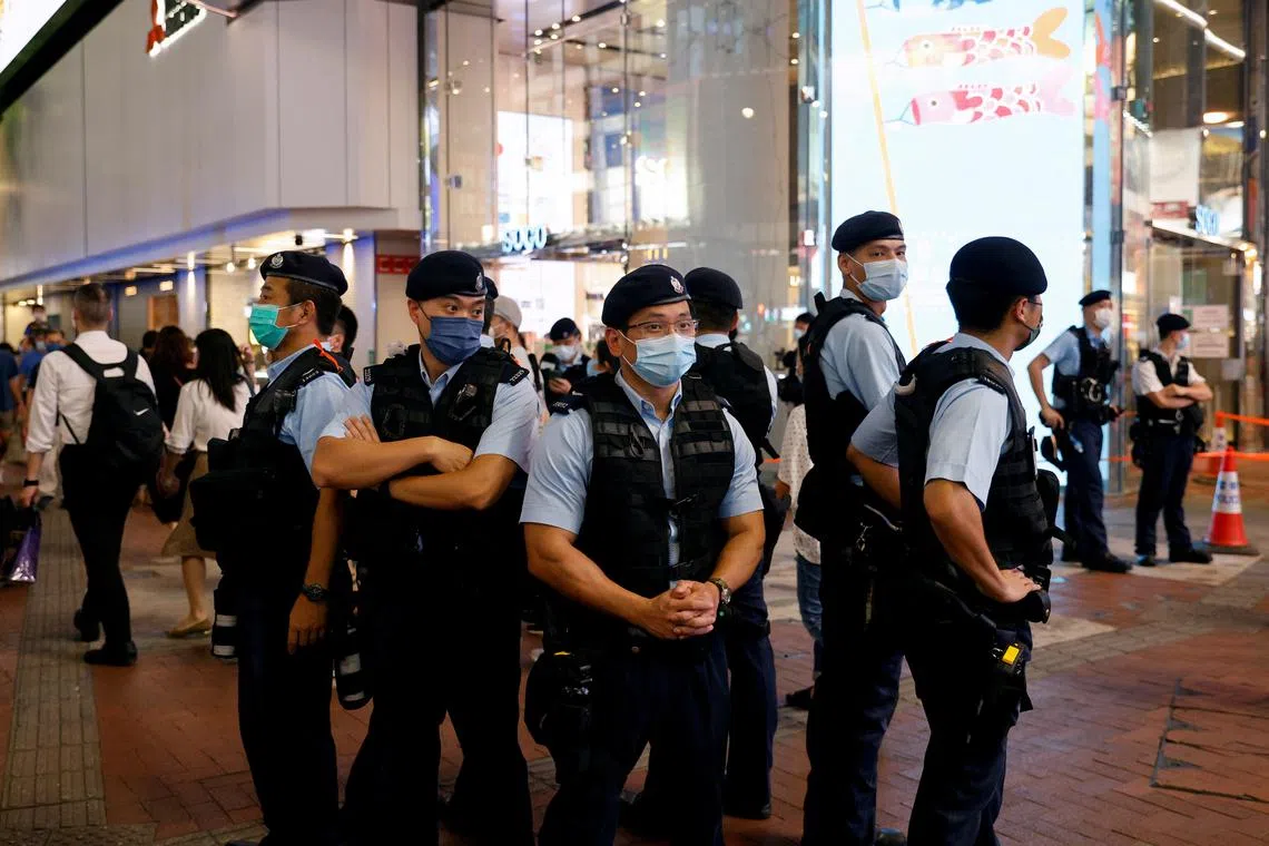 Police officers at the site where a man stabbed a policeman then stabbed himself in the chest in Hong Kong on July 2, 2021.
