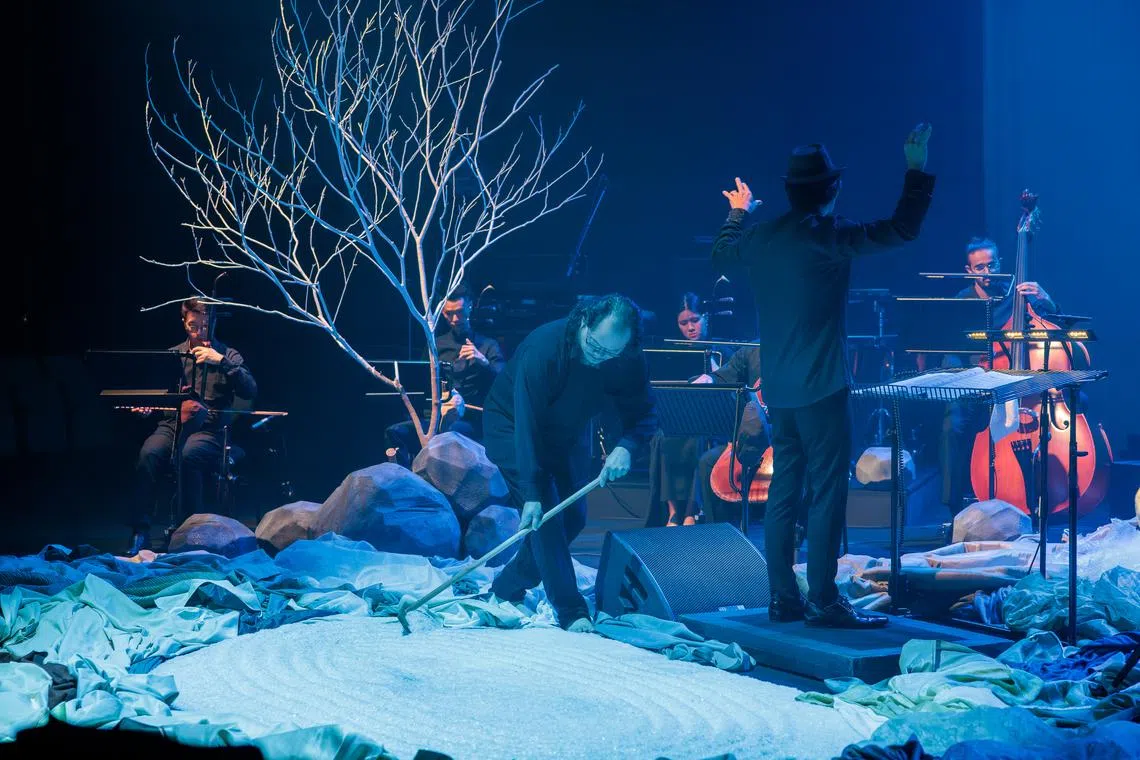 Composer Yii Kah Hoe rakes a mound of plastic flakes into a Zen garden. 