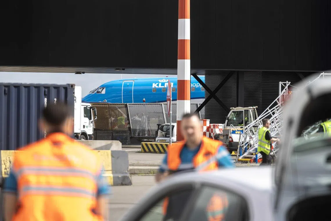 Emergency services attend at the airport where a person died after falling into running aircraft engine, at Schiphol, Netherlands, on May 29.