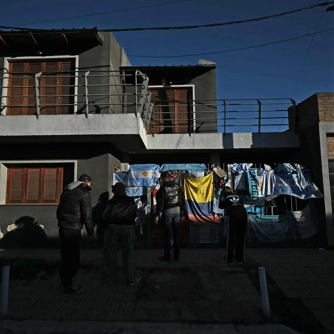People leaving flags and signs to pay respects on the fence of Argentina’s football star Lionel Messi’s birth house in Rosario, Santa Fe province, Argentina, on August 8, after his father, Jorge Messi, died.