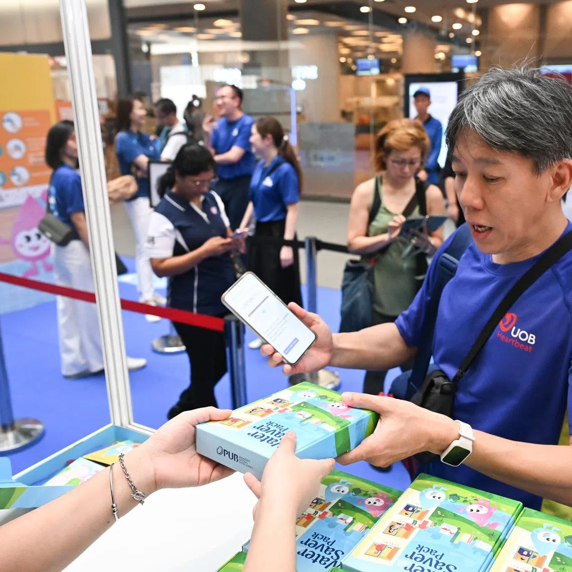 A member of the public receives a water saver pack at PUB’s annual Water Conservation Campaign held at Our Tampines Hub on March 8.