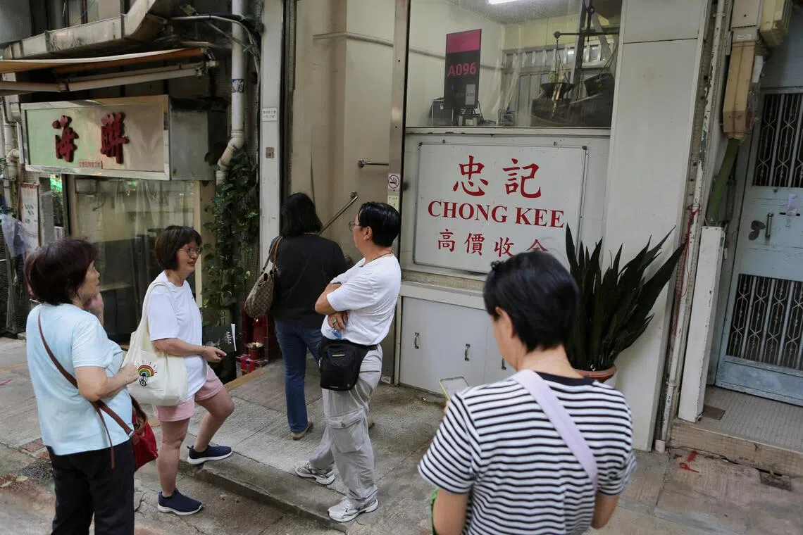 Customers wait outside Chong Kee gold shop, renowned for its competitive gold buyback rates amid surging prices, in Hong Kong, China, October 9, 2025. REUTERS/James Pomfret