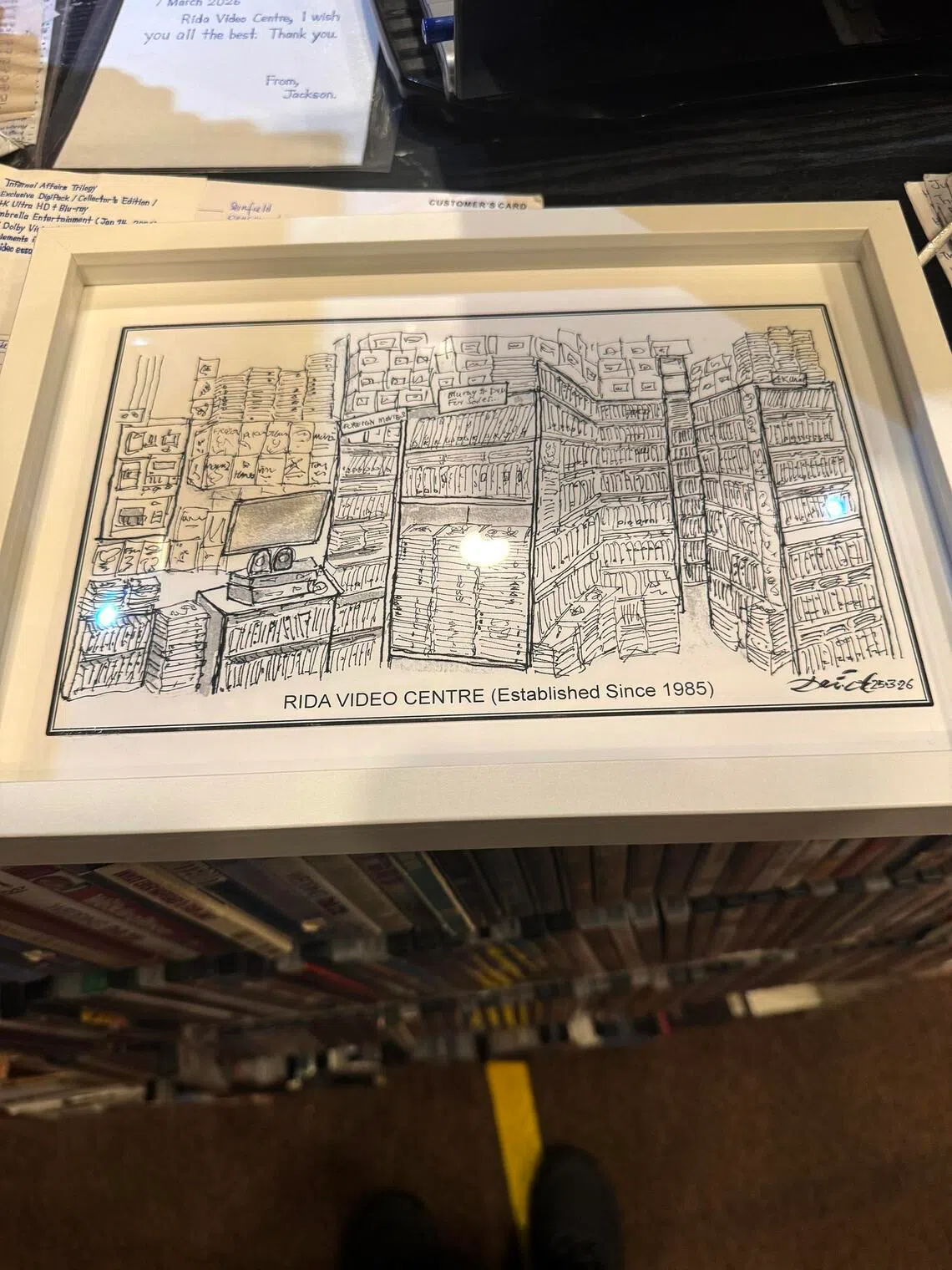 A gift from a customer, a sketch of the Rida Video Centre, which now stands behind the counter.
