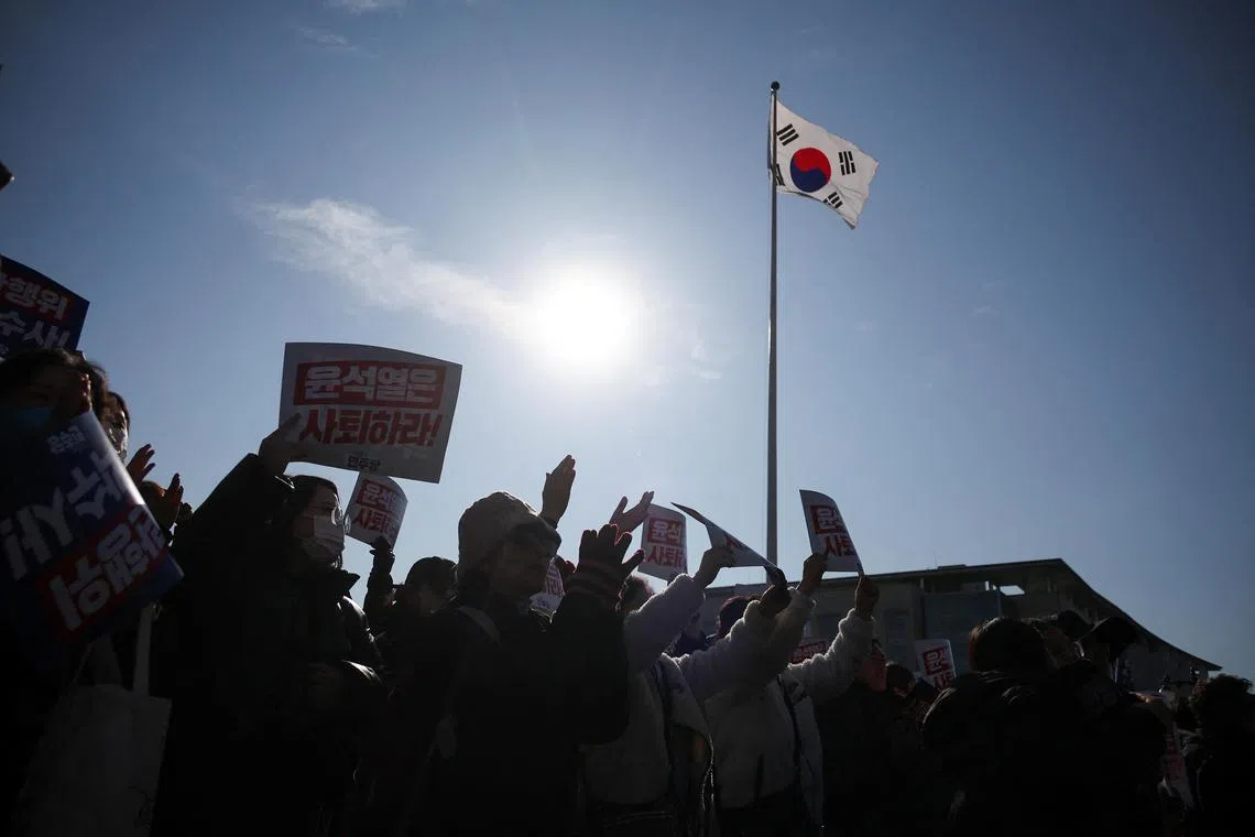 Protesters hold up signs at a rally condemning South Korean President Yoon Suk Yeol’s surprise declarations of the martial law and to call for his resignation, at the National Assembly in Seoul, on Dec 4, 2024.