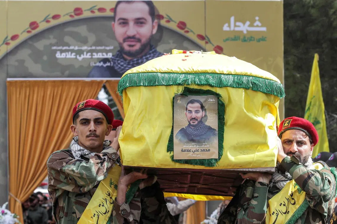 Hezbollah militants carrying the coffin of a member who was killed the previous day by the explosion of a communication device, in southern Lebanon on Sept 19.