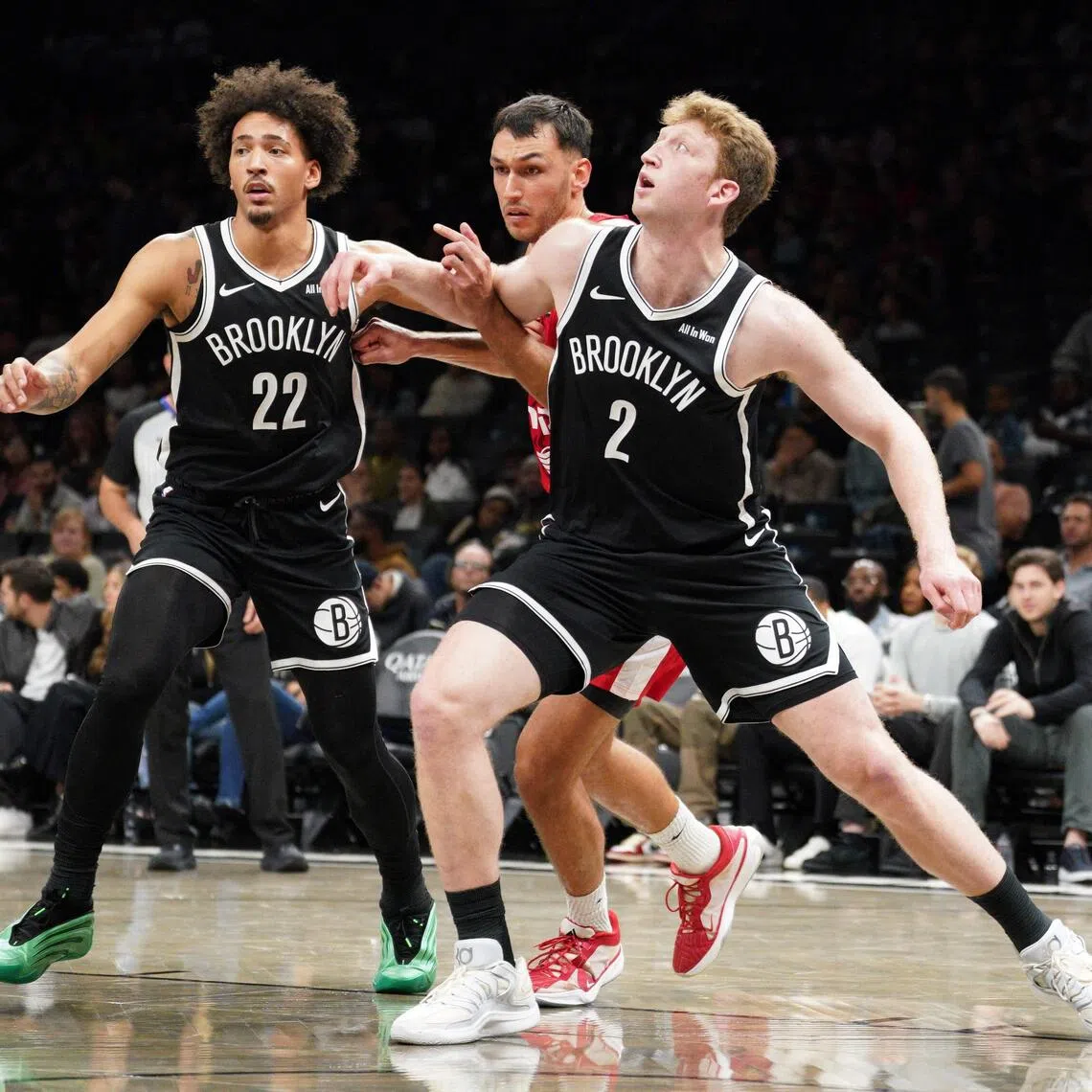 Danny Wolf and Jalen Wilson of the Brooklyn Nets fight for position with Nimrod Levi of Hapoel Jerusalem B.C. during a pre-season game. 