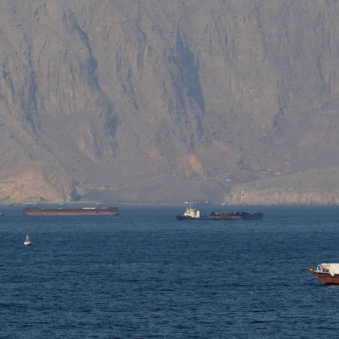 Ships and tankers in the Strait of Hormuz off the coast of Musandam, Oman. Escorting them safely will require immense resources, says the writer. 