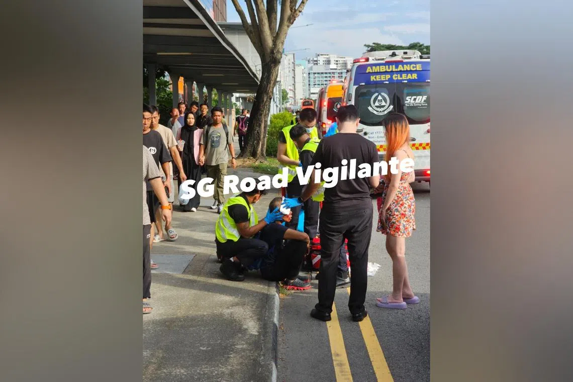 The cyclist, with a bloodied face, is seen seated on a pavement, with uniformed officers tending to his injuries.