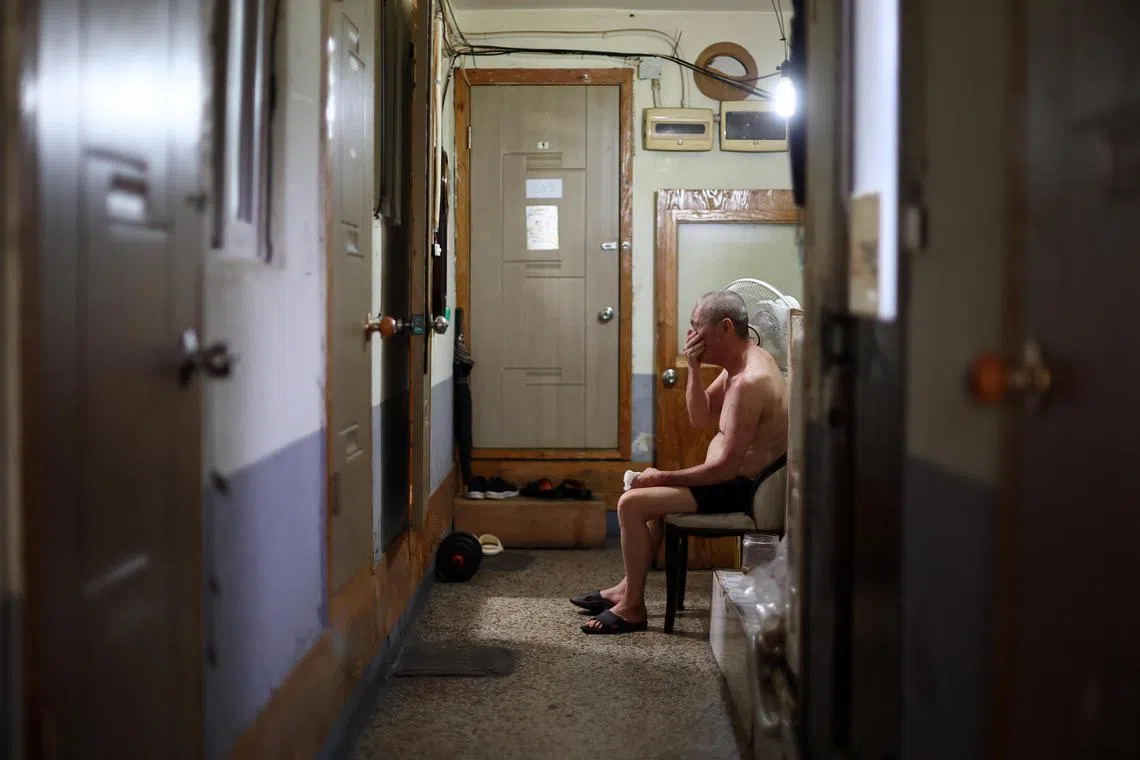 A man sits next to a fan to cool off at a flophouse in Seoul, where temperatures are hitting north of 35 deg C.