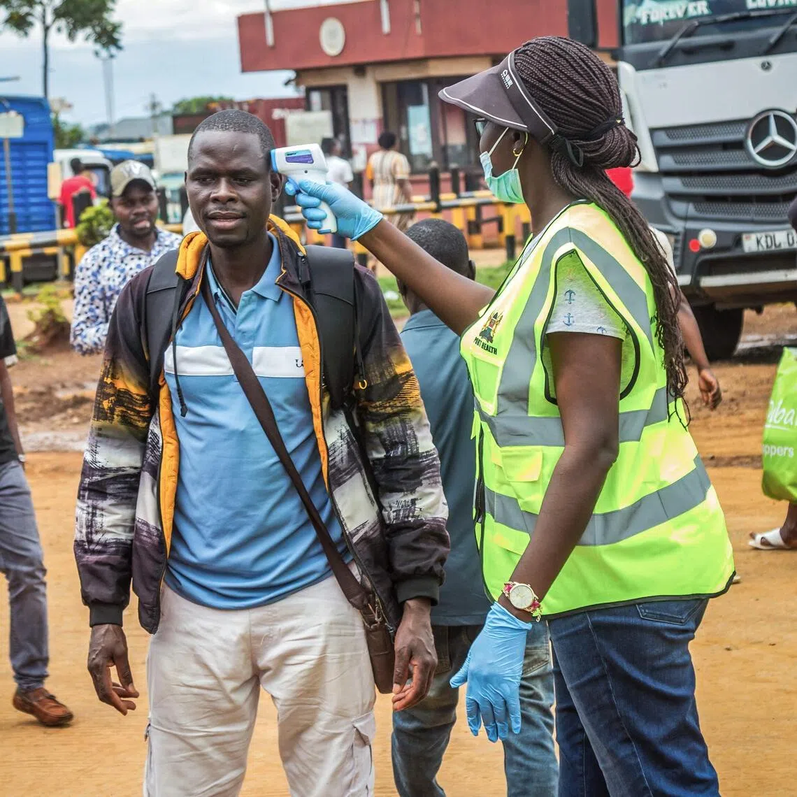 A Kenyan Ministry of Health official checking the temperature of a traveller at the border with Uganda on Oct 12.