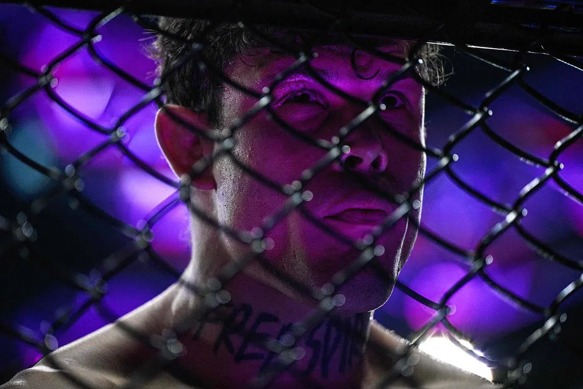 TOPSHOT - Brazil's Caio Borralho looks through the net prior to the bout against France's Nassourdine Imavov during their mixed martial arts at the 4th edition of the Ultimate Fighting Championship (UFC) average weights at the Bercy Accor Arena, in Paris, on September 6, 2025. (Photo by JULIEN DE ROSA / AFP)