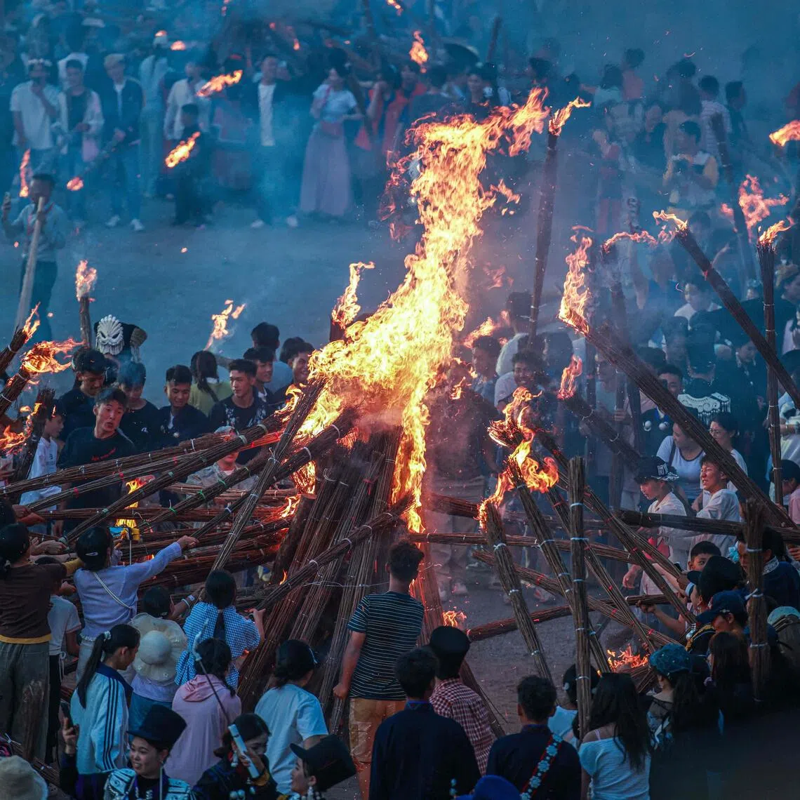 People burning torches as they celebrate the Torch Festival, held by the Yi ethnic minority, on July 19.