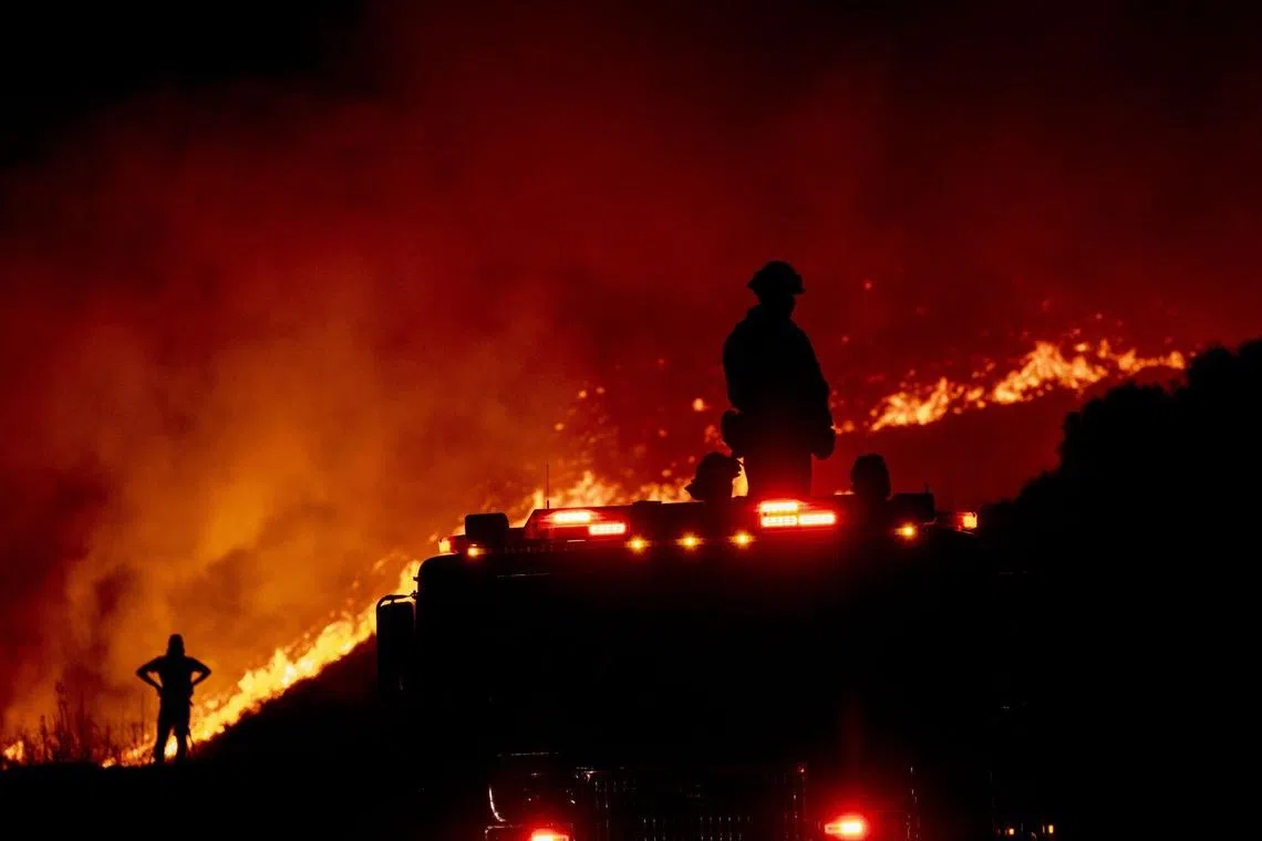 Firefighters observe from a firetruck on Charlie Canyon Road during the Hughes Fire in Castaic, California, US, on Wednesday, Jan. 22, 2025. Fire crews are making progress on blunting the threat from the Hughes Fire, an enormous new blaze north of Los Angeles, that forced students to evacuate and prompted inmates to shelter in place. Photographer: Jill Connelly/Bloomberg