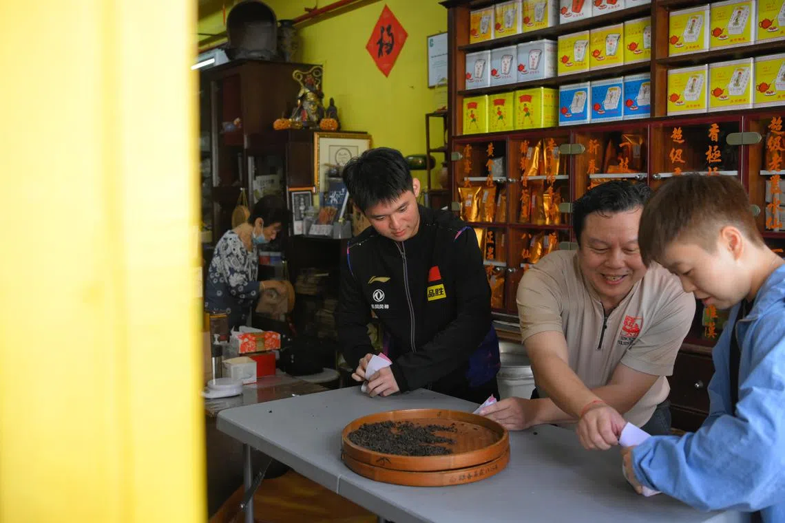 Ahead of the World Table Tennis Singapore Smash 2023, Chinese players Lin Shidong (far left) and Zhang Rui (far right) had a tea making session at Pek Sin Choon with fourth-generation owner Kenry Peh in Chinatown on March 9.