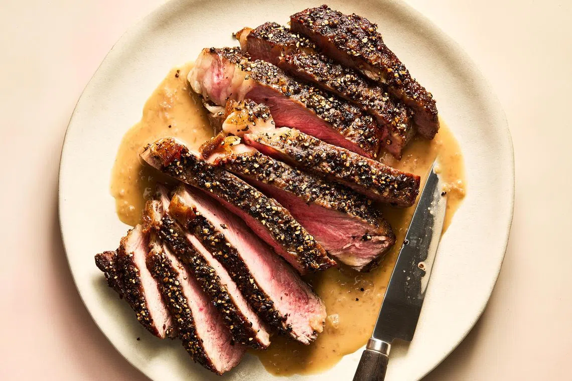 Steak au poivre. Like many treasured French dishes, steak au poivre abides by certain tenets: It begins with a piece of beef that is crusted in crushed peppercorns and ends with a glossy, peppery pan sauce. Food styled by Brett Regot. (Armando Rafael/The New York Times)