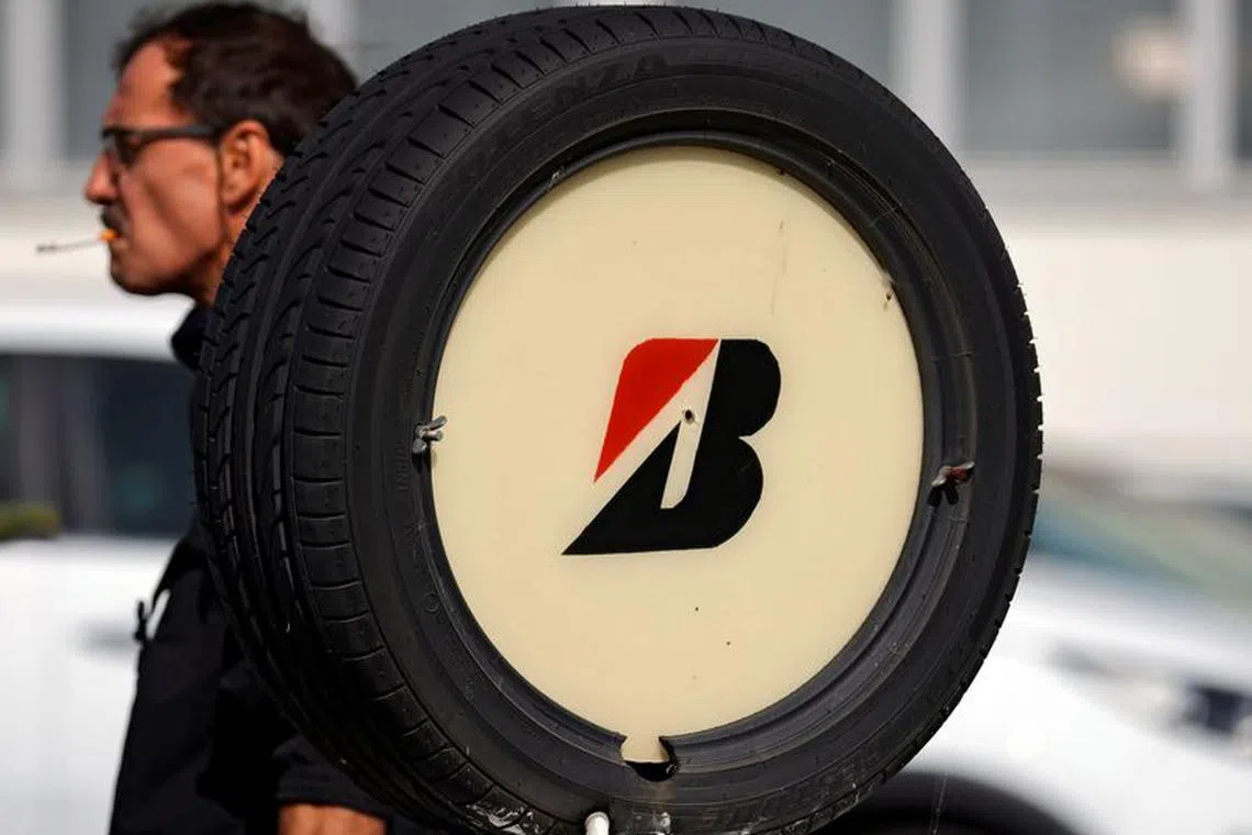 A worker walks past a tyre with Bridgestone's logo at the company's tyre plant in Bethune, that Japan's Bridgestone plans to shut, France, September 17, 2020. Picture taken September 17, 2020. REUTERS/Pascal Rossignol/File Photo