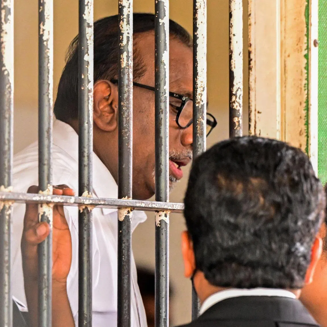 Sri Lanka’s former sports minister Mahindananda Aluthgamage (L) speaks to a lawyer at a court in Colombo on May 29, 2025. A Sri Lankan court on May 29 sentenced two former ministers from the government of deposed president Gotabaya Rajapaksa to decades in prison in a landmark corruption case. (Photo by Ishara S. KODIKARA / AFP)