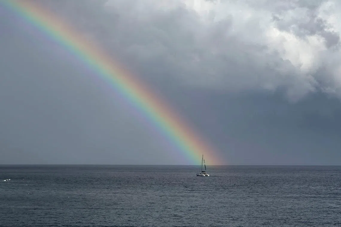 A rainbow appearing after a heavy rainfall as a catamaran sails in Adriatic sea, seen from the town of Bol at the island of Brac, Croatia, Aug 30.