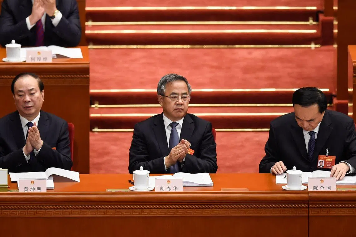 Chinese Vice Premier Hu Chunhua (C) applauds during the opening session of the National People's Congress (NPC) at the Great Hall of the People in Beijing on March 5, 2019. (Photo by WANG ZHAO / AFP)
