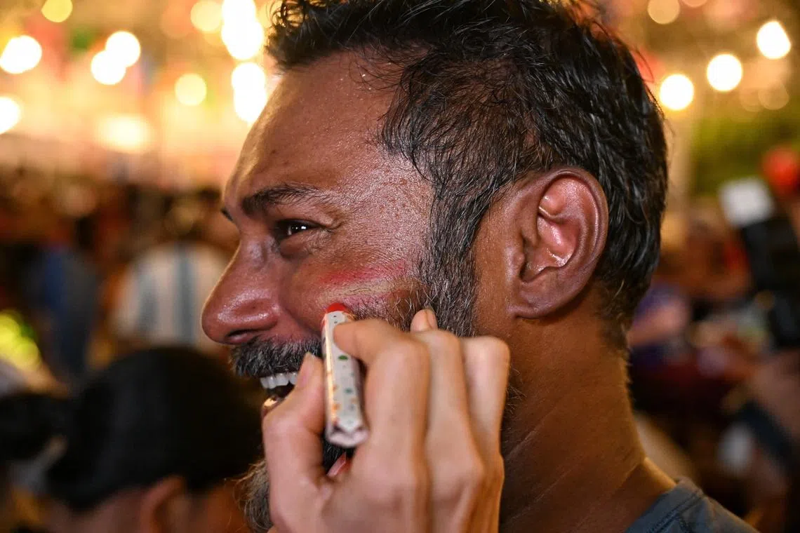 A spectator getting the Spanish colours drawn on his face at CHIJMES before the FIFA World Cup finals screening on July 20, 2026. ST PHOTO: AZMI ATHNI