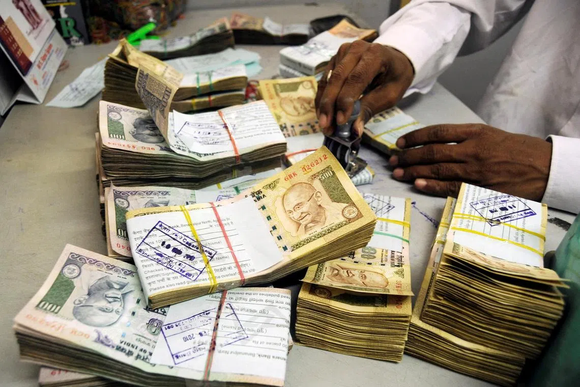 FILE PHOTO: An employee arranges Indian currency notes at a cash counter inside a bank in the northeastern Indian city of Agartala February 18, 2010. REUTERS/Jayanta Dey/File Photo