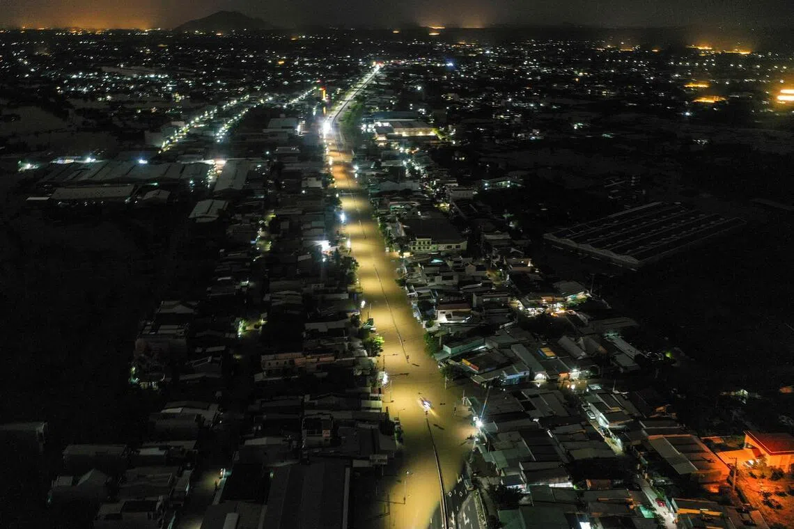 Water floods a road next to residential buildings in Vietnam's Lam Dong province on Dec 5, 2025, following weeks of heavy rain.