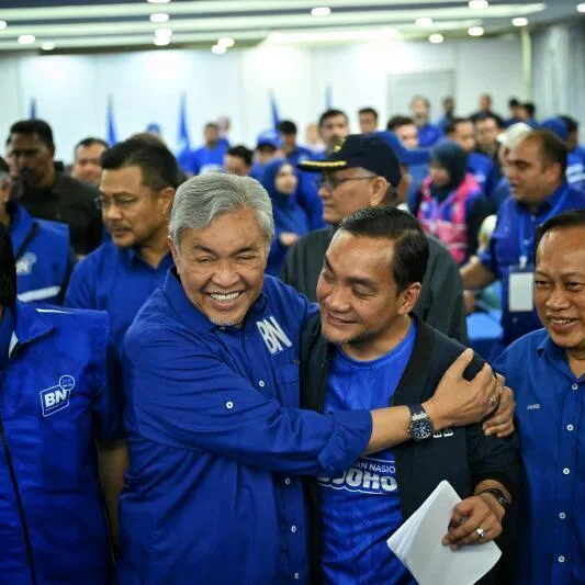 Barisan Nasional Ahmad Zahid Hamidi embraces Johor Chief Minister Onn Hafiz Ghazi after the bloc’s crushing victory in the July 11 Johor state election..