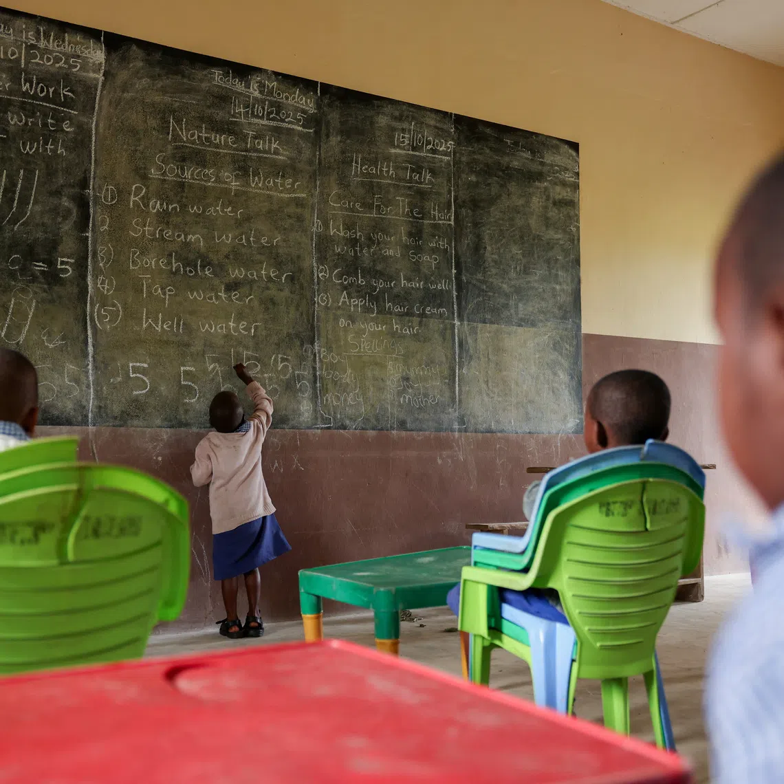 A boy accused of witchcraft by his mother writes on a blackboard in a class exercise in Eket, Akwa Ibom state, Nigeria, October 15, 2025. REUTERS/Sodiq Adelakun
