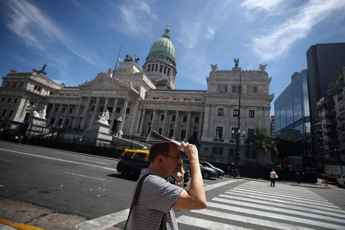 FILE PHOTO: A man shields himself from the sun during a heatwave as lawmakers debate on Argentina's President Javier Milei's economic reform bill, known as the 'omnibus bill', outside the National Congress, in Buenos Aires, Argentina, February 2, 2024. REUTERS/Agustin Marcarian/File Photo
