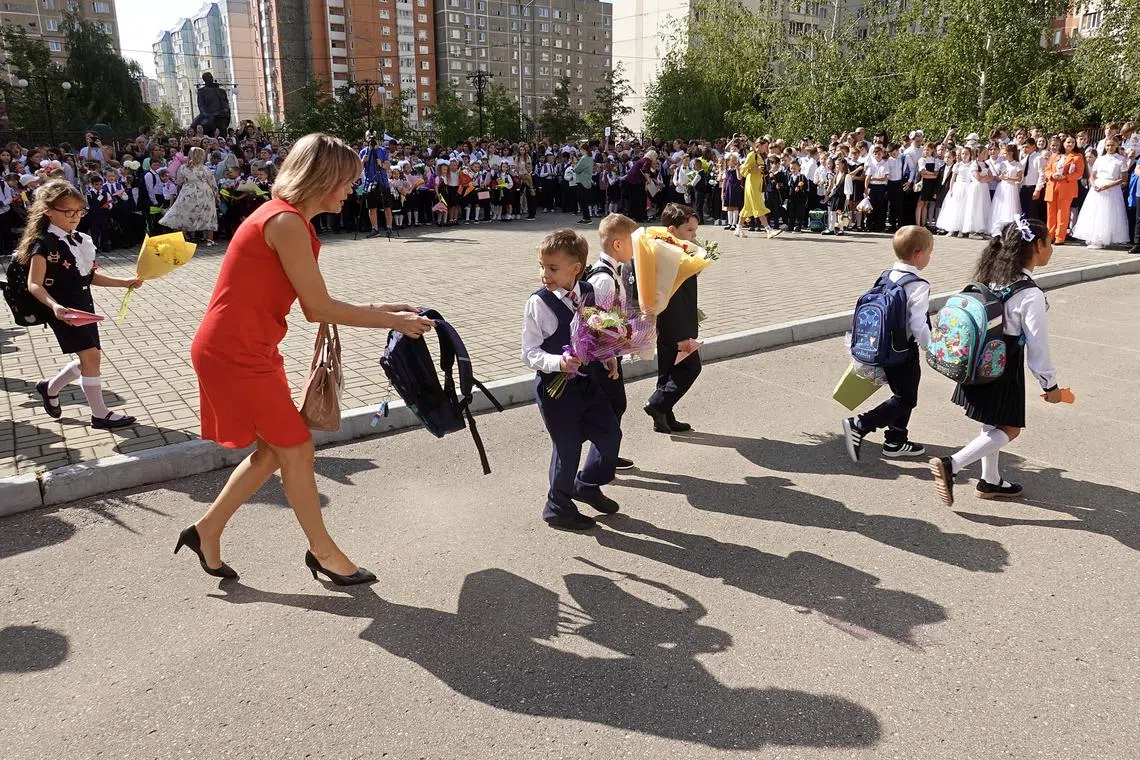 A woman assists a schoolchild during a first-graders' ceremony to mark the start of the school year in Podolsk, outside Moscow, on Sept 1.