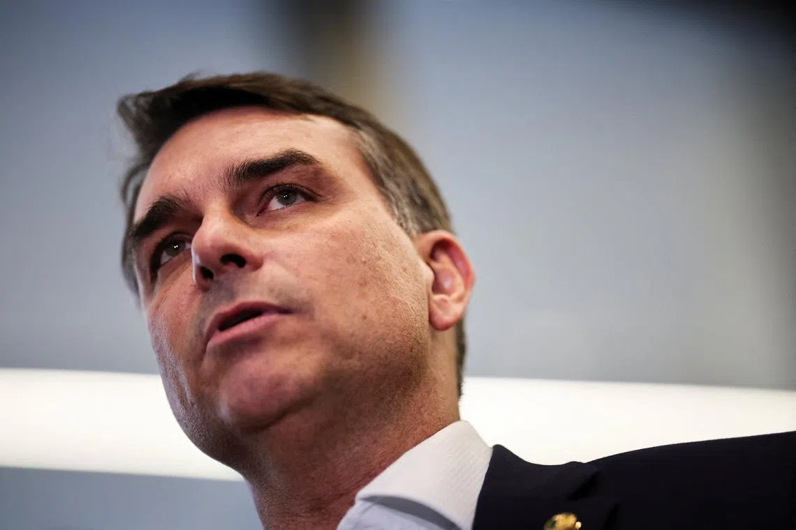 Flavio Bolsonaro speaks with members of the press after a meeting, following a scandal over messages tied to his request for funding for a biopic about former Brazilian President Jair Bolsonaro, from disgraced banker Daniel Vorcaro, who was arrested in March on suspicion of leading a multibillion-dollar fraud scheme, in Brasilia, Brazil, May 19, 2026. REUTERS/Mateus Bonomi/File Photo