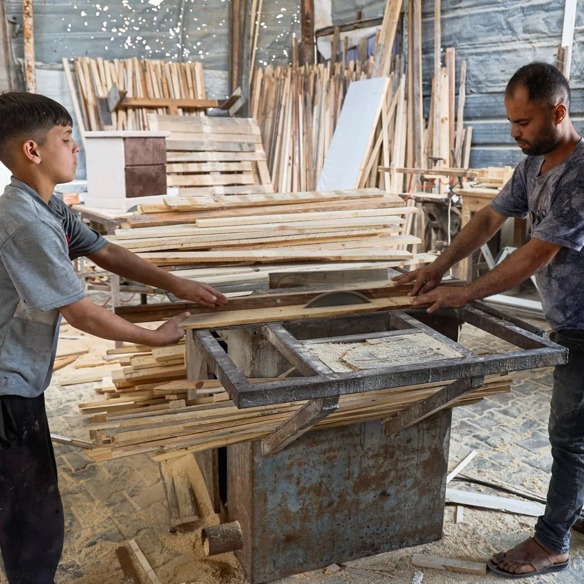Palestinian carpenter Mohammed Wafi builds furniture from recycled wooden pallets in his workshop amid shortages of materials in Khan Younis, in the southern Gaza Strip, May 2, 2026. REUTERS/Haseeb Alwazeer