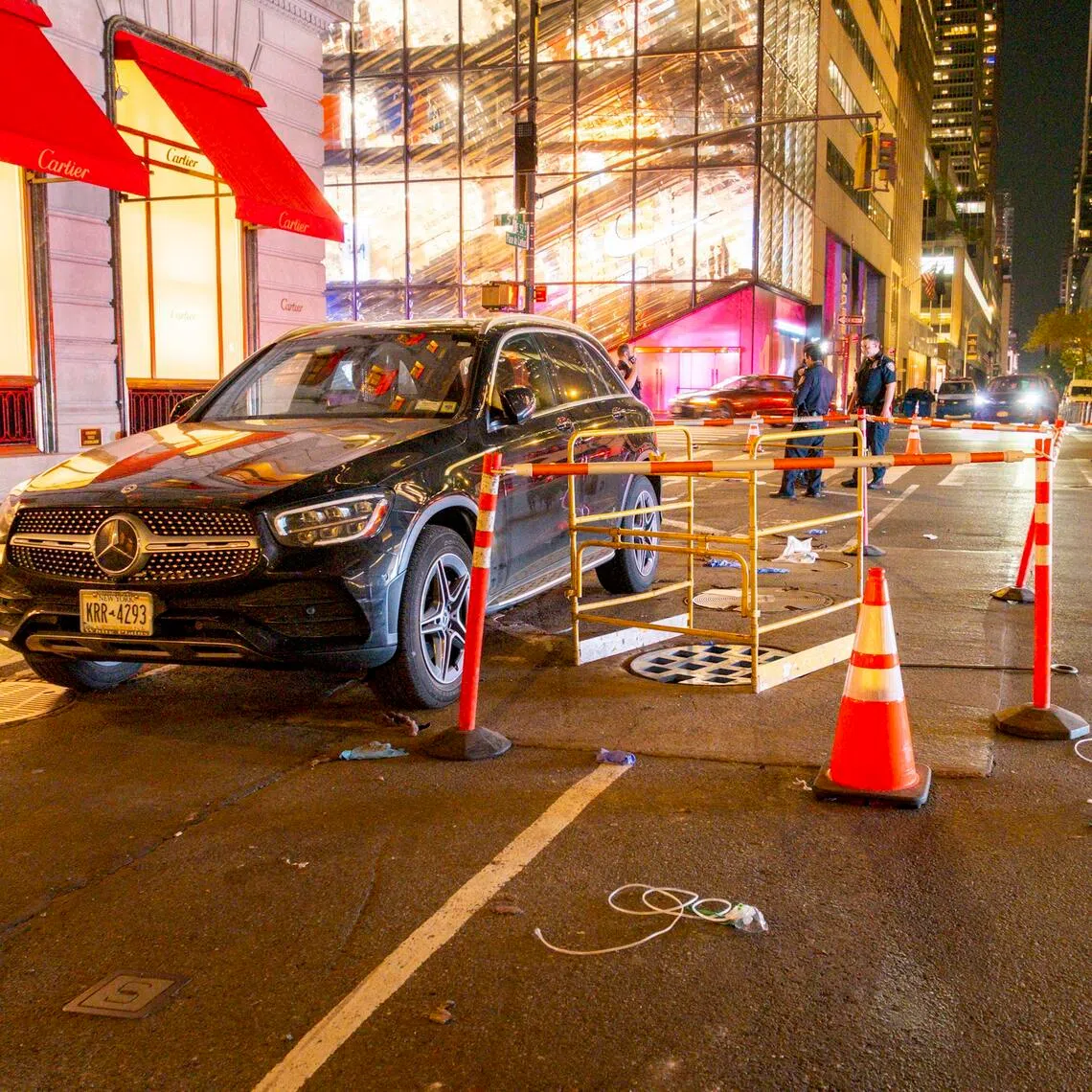 Police officers near a manhole in New York on May 19, where a 56-year-old woman died after she fell into it.