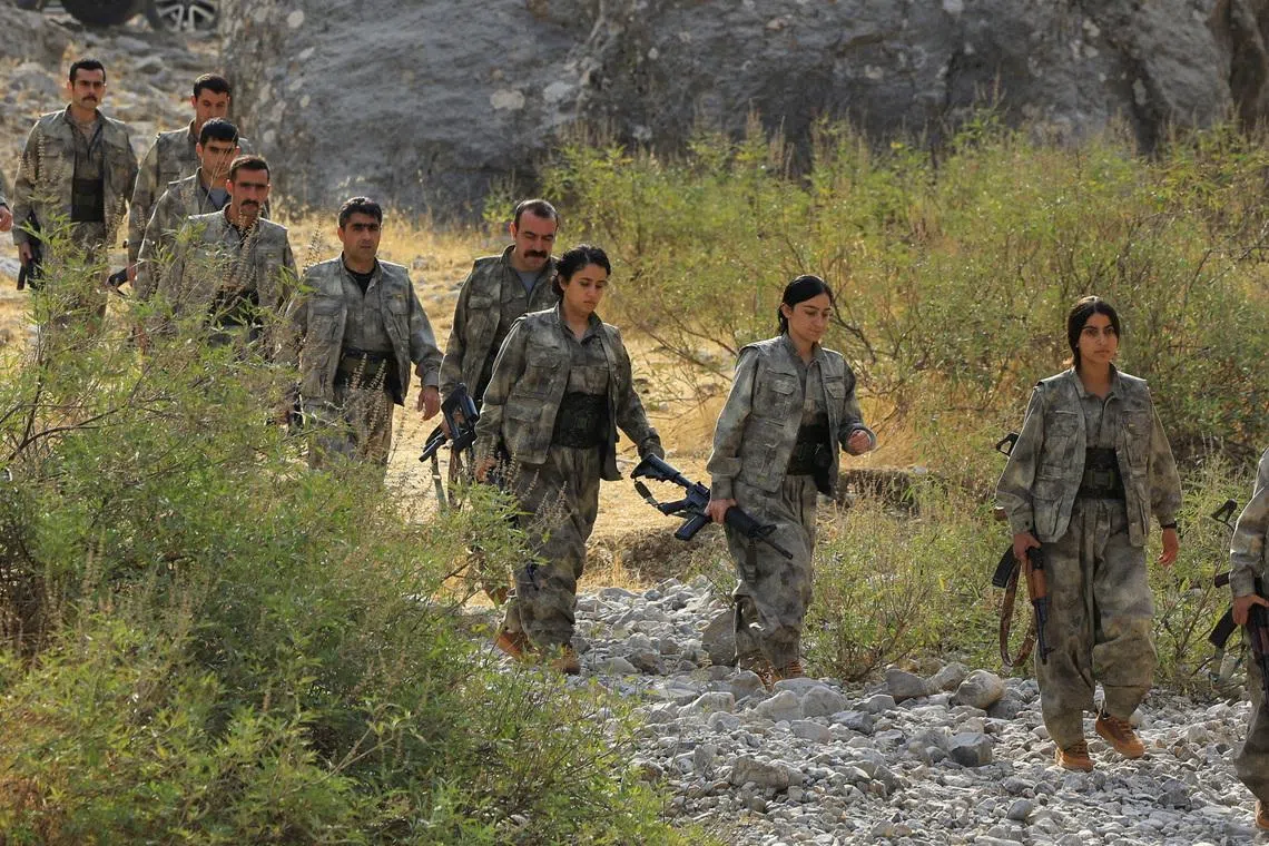 Fighters with the Kurdistan Workers' Party (PKK) walk for a disarmament ceremony marking a significant step toward ending the decades-long conflict between Turkey and the outlawed group, in the Qandil mountains, Iraq October 26, 2025. REUTERS/Thaier Al-Sudani