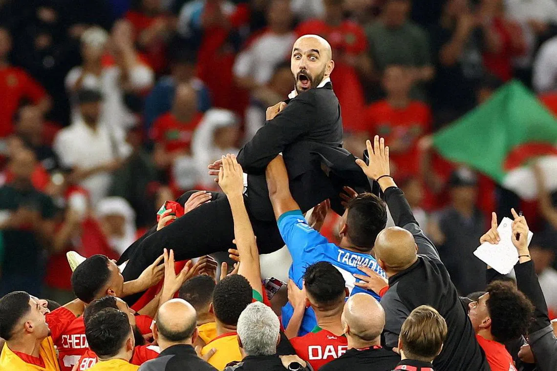 Morocco coach Walid Regragui celebrates with the players after the match, as Morocco progress to the semi finals.    